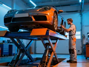 Mechanik dokonujący profesjonalnego przeglądu podwozia samochodu w warsztacie przed jego zakupem.